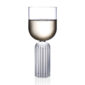 Minimalist studio display of a Fferrone May Medium Glass in fluted borosilicate glass filled with white wine featuring a smooth U-shaped bowl and a ribbed cylindrical pedestal base | Kneen & Co