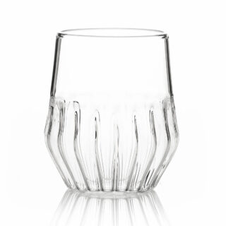 Minimalist studio display of a FFferrone Mixed Small Glass in fluted borosilicate glass featuring a tapered silhouette and a short ribbed base | Kneen & Co