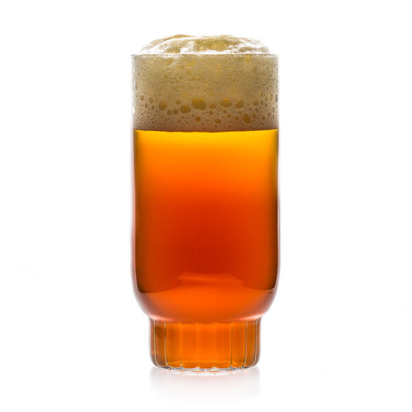 Minimalist studio display of a Fferrone Rasori Glassware in fluted borosilicate glass filled with amber beer and foam | Kneen & Co