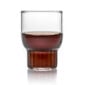 Minimalist studio display of a Fferrone Rasori Mini Glass in fluted borosilicate glass filled with a dark spirit | Kneen & Co