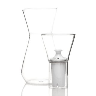 Minimalist studio display of a Fferrone Talise Carafe in clear borosilicate glass featuring a smooth tapered carafe and a matching funnel with a white filter insert | Kneen & Co