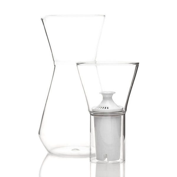 Minimalist studio display of a Fferrone Talise Carafe in clear borosilicate glass featuring a smooth tapered carafe and a matching funnel with a white filter insert | Kneen & Co