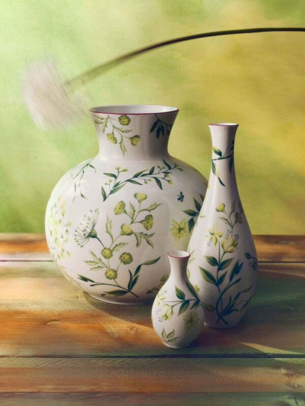 GINORI-FLORENZA-SET-05-0037-1200w-100KB Warmly lit wooden surface with Ginori 1735 Florenza vases in fine porcelain featuring green botanical illustrations and delicate pink rim detailing | Kneen & Co