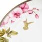 Close-up shot of Wedgwood Hummingbird Oval Platter defined by expressive floral motifs and an artfully sculpted bird finial finished with 22-carat gold detailing | Kneen & Co