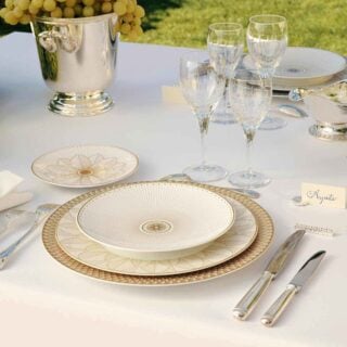 CHRISTOFLE-MALMAISON-IMPERIALE-2026-RGB-HD-2-1200w-100KB Elegant garden table set with the Christofle Malmaison Impériale collection in fine Limoges porcelain featuring intricate gold-leaf detailing | Kneen & Co