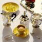 Overhead lifestyle shot of a Christofle Malmaison Riviera Coffee Cup and Saucer in yellow Limoges porcelain | Kneen & Co