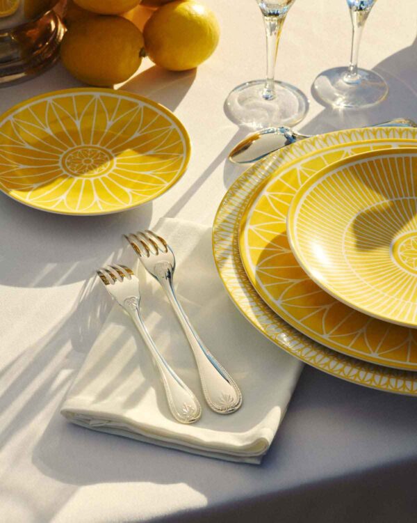 CHRISTOFLE-MALMAISON-RIVIERA-2026-RGB-HD-11-1200w-100KB Close-up lifestyle shot of a Christofle Malmaison Riviera place setting in yellow Limoges porcelain | Kneen & Co
