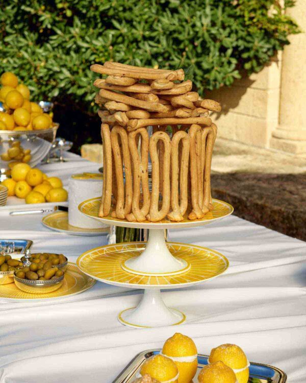 Gourmet outdoor buffet display featuring Christofle Malmaison Riviera Footed Cake Stands in yellow Limoges porcelain | Kneen & Co