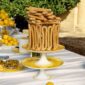 Gourmet outdoor buffet display featuring Christofle Malmaison Riviera Footed Cake Stands in yellow Limoges porcelain | Kneen & Co