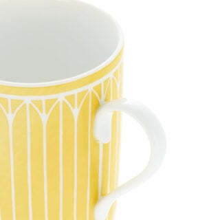 Close-up shot of Christofle Malmaison Riviera Mug in yellow Limoges porcelain with hand-drawn palmette detailing | Kneen & Co