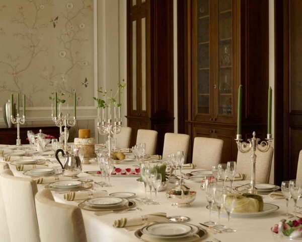 CHRISTOFLE-NewMalmaison-Mood-2026-RGB-HD-1-1200w-100KB Grand formal dining room setting featuring Christofle Malmaison dinnerware | Kneen & Co