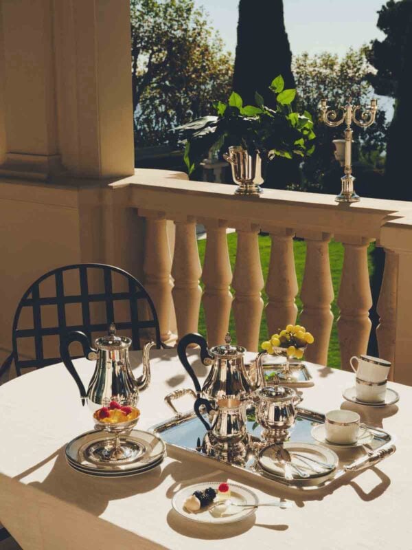 CHRISTOFLE-NewMalmaison-Mood-2026-RGB-HD-13-1200w-100KB Sun-drenched setting featuring a Christofle Malmaison Silver-Plated Tea and Coffee Service | Kneen & Co