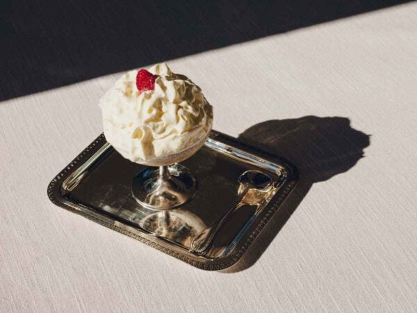 CHRISTOFLE-NewMalmaison-Mood-2026-RGB-HD-16-1200w-100KB Lifestyle setting featuring a Christofle Malmaison footed dessert bowl in silver plate | Kneen & Co