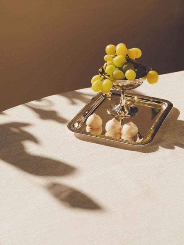 CHRISTOFLE-NewMalmaison-Mood-2026-RGB-HD-18-1200w-100KB Warmly lit afternoon setting featuring a Christofle Malmaison footed bowl in silver plate | Kneen & Co
