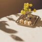 Warmly lit afternoon setting featuring a Christofle Malmaison footed bowl in silver plate | Kneen & Co