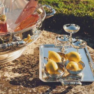 Golden hour garden setting featuring a Christofle Malmaison large silver-plated ice bucket champagne coupes | Kneen & Co