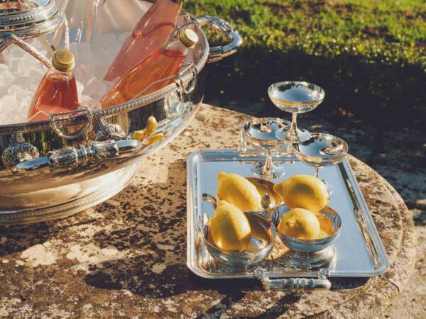 Golden hour garden setting featuring a Christofle Malmaison large silver-plated ice bucket champagne coupes | Kneen & Co