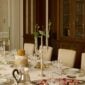 Stately formal dining setting featuring Christofle Malmaison showcasing mirror-polished silver finishes and neoclassical leaf engravings on a layered tablescape | Kneen & Co