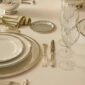 Close-up of a formal place setting featuring Christofle Malmaison porcelain plates and silver-plated flatware | Kneen & Co