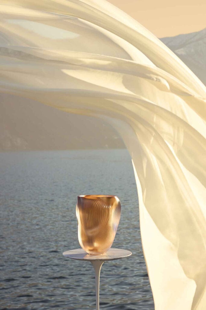Lalique Alizé Large Vase with Pink Gold Leaves set on table with ocean backdrop | Kneen & Co