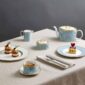Elegant afternoon tea service on a linen tablecloth with Wedgwood Helia Tea Set in fine bone china with gold banding and light blue pinstripe pattern | Kneen & Co