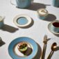 Modern dinner setting with Wedgwood Helia Dinnerware in fine bone china with 22-carat gold trim and blue pinstripe borders | Kneen & Co