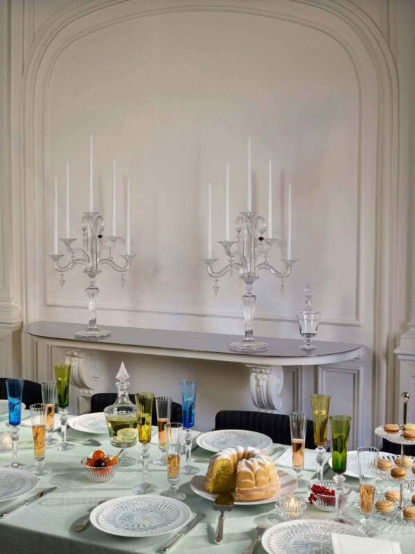 Elegant dining table featuring Baccarat Mille Nuits crystal votives glowing among colorful crystal stemware, clear crystal decanters, and white dinnerware, with matching Baccarat crystal candelabras displayed in the background | Kneen & Co