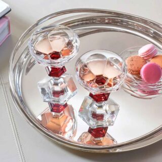BACCARAT-2814393-Lifestyle-1-1200w-100KB Baccarat Harcourt 1841 Coupes, Set of 2 filled with rosé champagne on a polished silver tray, showcasing the collection's signature red crystal accents and hexagonal base | Kneen & Co