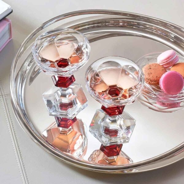 Baccarat Harcourt 1841 Coupes, Set of 2 filled with rosé champagne on a polished silver tray, showcasing the collection's signature red crystal accents and hexagonal base | Kneen & Co