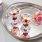 Baccarat Harcourt 1841 Coupes, Set of 2 filled with rosé champagne on a polished silver tray, showcasing the collection's signature red crystal accents and hexagonal base | Kneen & Co