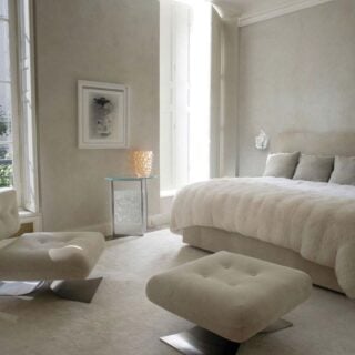 Elegant luxury bedroom setting with Lalique Champs-Elysées Wall Sconce in clear crystal and a chrome finish mounted on the wall | Kneen & Co