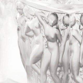 Close-up studio shot of the Lalique Révélation Bacchantes Vase in clear crystal, showcasing the intricate satin-finish | Kneen & Co