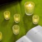 Cozy interior setting with glowing Lalique Mossi Votives in clear crystal, featuring the iconic repeating cabochon pattern | Kneen & Co