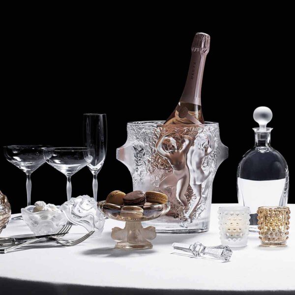 LALIQUE-1095600-mossi-votive-2-1200w-100KB Elegant table setting featuring the Lalique Mossi Votive in clear crystal with repeating cabochons creating a kaleidoscopic light effect, alongside champagne and crystal barware | Kneen & Co