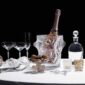 Elegant table setting featuring the Lalique Mossi Votive in clear crystal with repeating cabochons creating a kaleidoscopic light effect, alongside champagne and crystal barware | Kneen & Co