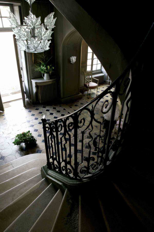 LALIQUE-Champs-Elysees-Lifestyle-Nmbr1012199-1200w-100KB Stone staircase featuring the Lalique Champs-Élysées Chandelier in clear crystal, designed with tiered, frosted oak leaves | Kneen & Co