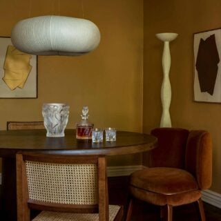 Sophisticated warm-toned dining room featuring the Lalique Bacchantes Vase in clear and frosted satin-finished crystal | Kneen & Co