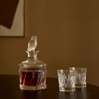 Lalique Owl Collection featuring a crystal owl decanter and matching owl tumblers styled with whiskey | Kneen & Co