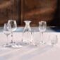 Lalique Owl Decanter and Owl Tumblers in clear crystal displayed with whiskey on a dark wood table | Kneen & Co