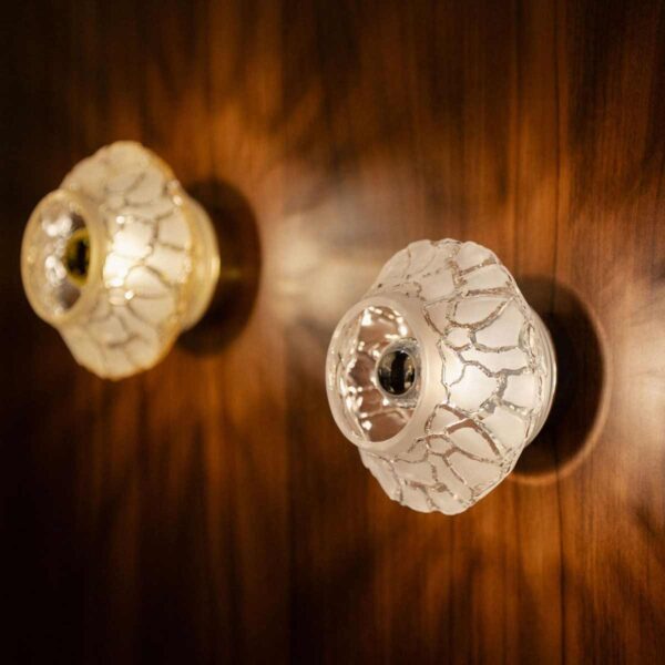 Warm interior setting featuring the Lalique Caldera Wall Lamps in frosted and clear crystal, showcasing a dramatic cracked volcanic texture when illuminated | Kneen & Co