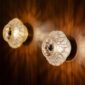 Warm interior setting featuring the Lalique Caldera Wall Lamps in frosted and clear crystal, showcasing a dramatic cracked volcanic texture when illuminated | Kneen & Co