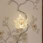 Elegant interior setting featuring the Lalique Champs-Élysées Wall Sconce in clear and frosted crystal, glowing softly to highlight its stylized oak leaf shape | Kneen & Co