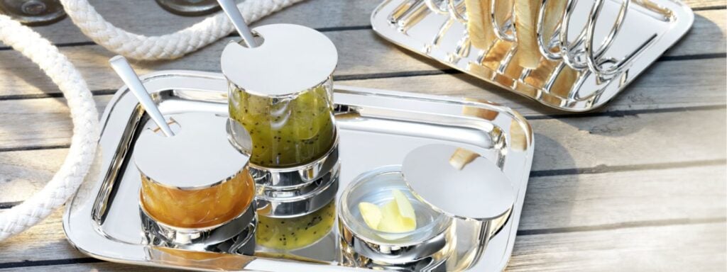 Robber & Berling Silver toast rack, jam jars, and butter dish on a sunlit wooden dock The Rise of "Healthy Luxury" Dining | Kneen & Co