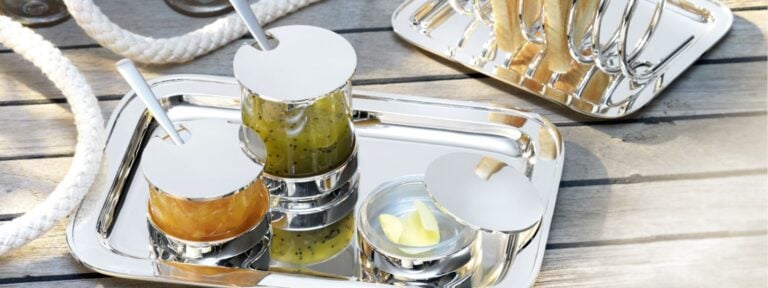 Robber & Berling Silver toast rack, jam jars, and butter dish on a sunlit wooden dock The Rise of "Healthy Luxury" Dining | Kneen & Co
