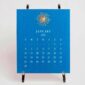 The Printery 2027 Calendar - Cornflower, white text with starburst engraved in gold | Kneen & Co