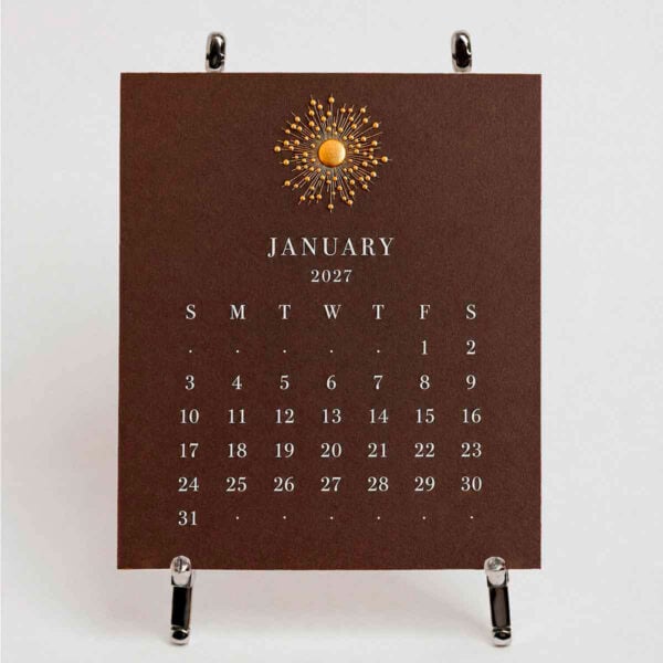 The Printery 2027 Calendar - Espresso, white text with starburst engraved in gold | Kneen & Co