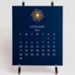 The Printery 2027 Calendar - Navy, white text with starburst engraved in gold | Kneen & Co