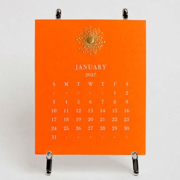 The Printery 2027 Calendar - Orange, white text with starburst engraved in gold | Kneen & Co