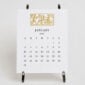 The Printery 2027 Calendar - White, black text with twelve motifs engraved in gold | Kneen & Co